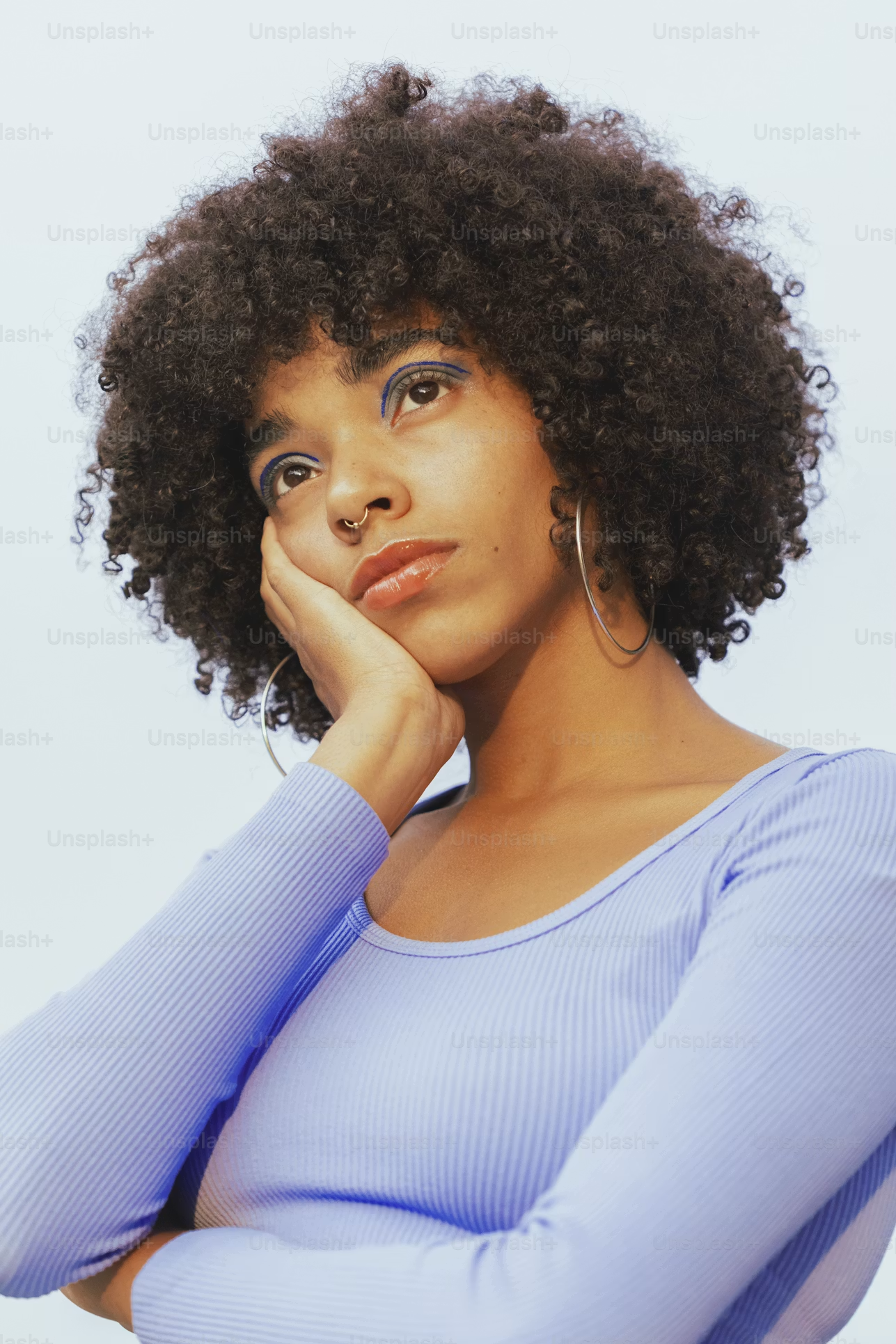 A woman in a lavender shirt staring off into the distance